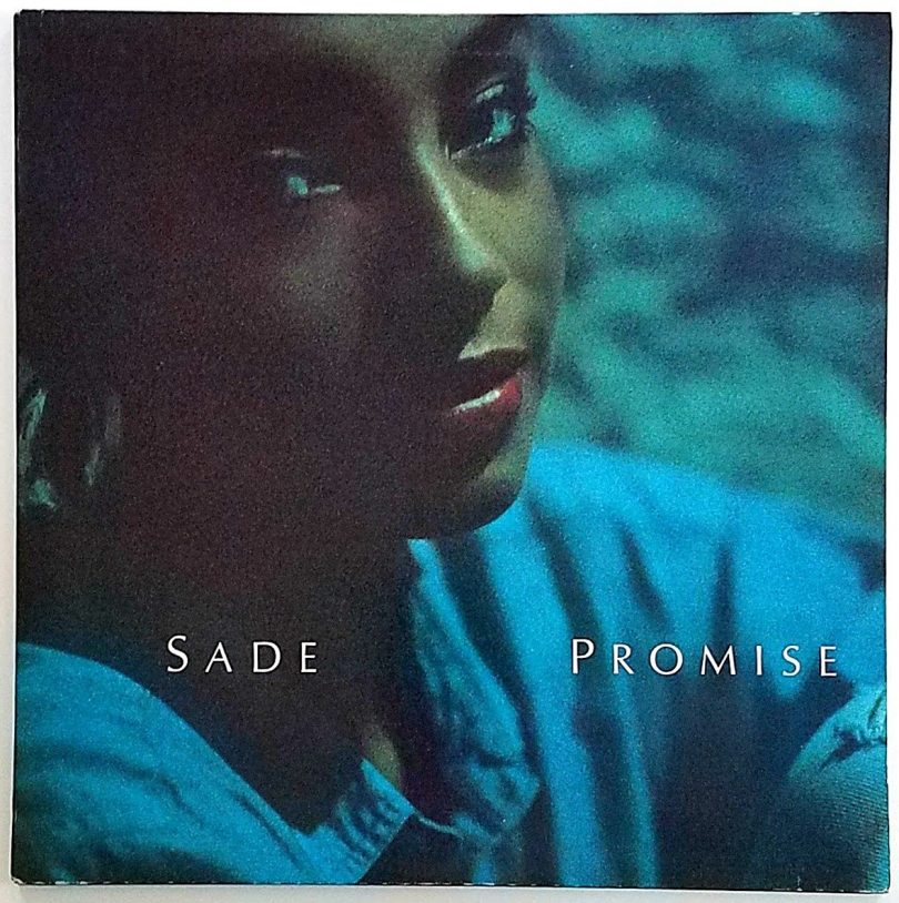 album cover with brown-skinned female in blue shirt with working Sade Promise