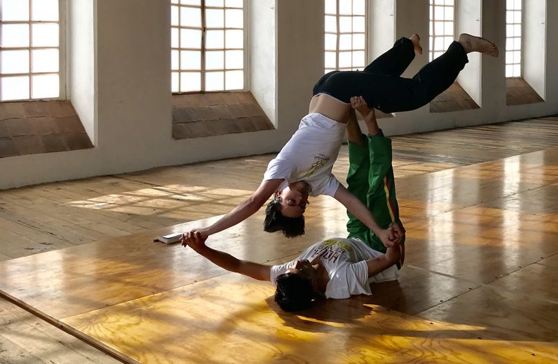 two people doing acrobatic yoga in a studio