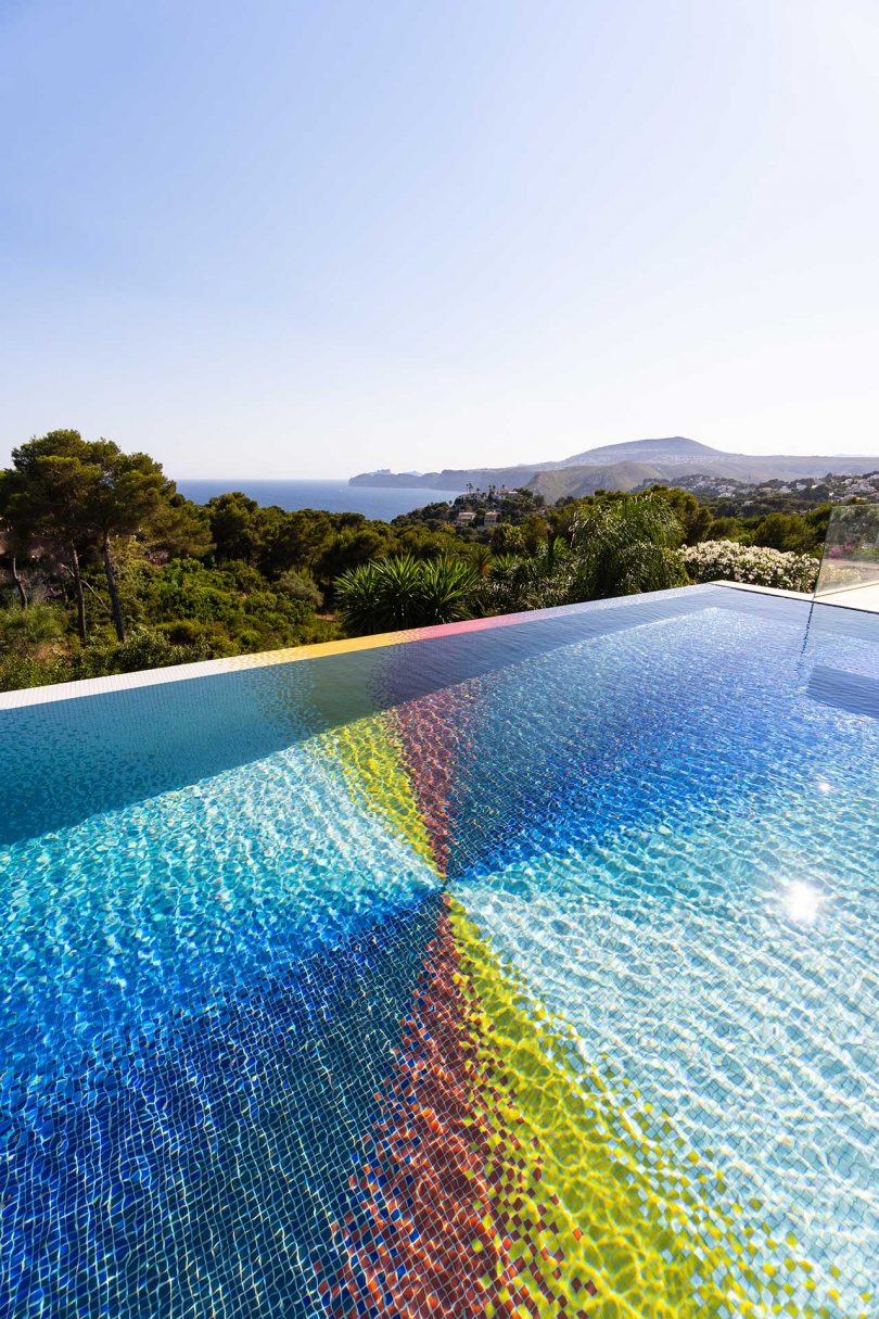 angled view looking over a colorful swimming pool with greenery in distance