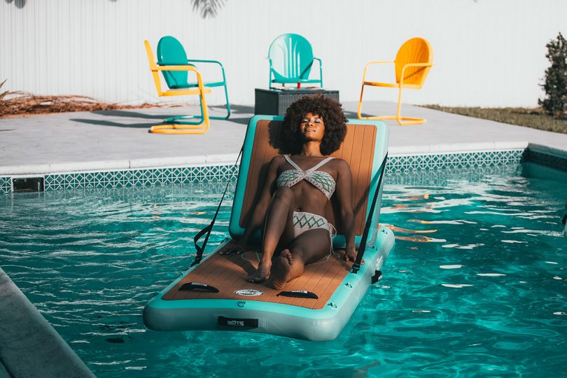 woman relaxing on a floating lounge chair in a pool