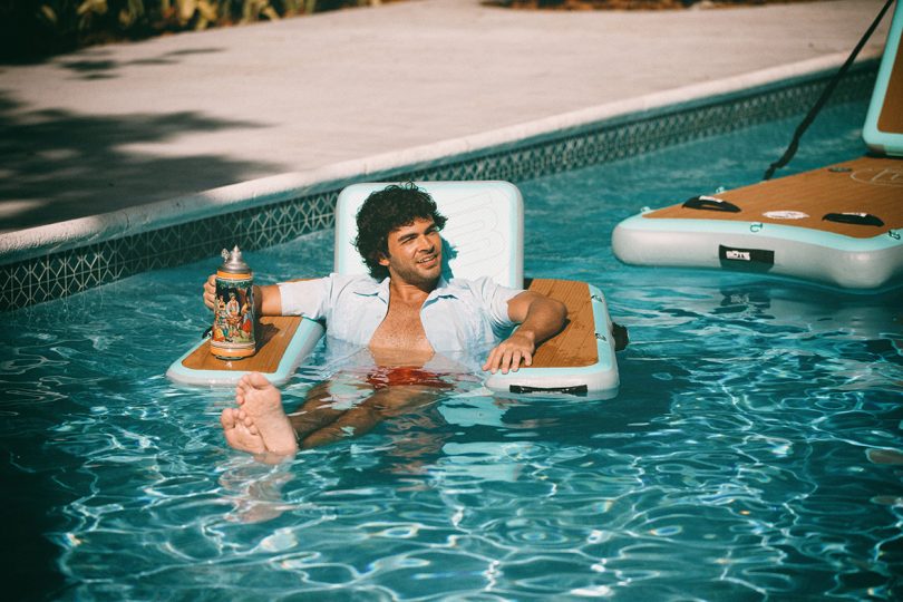 man relaxing on a floating lounge chair in a pool