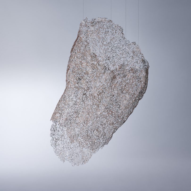 hanging wire sculpture on a light gray background