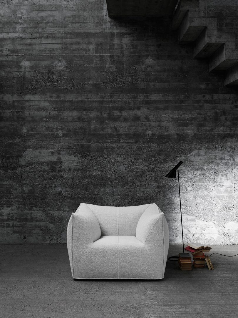 white armchair in front of a brick wall