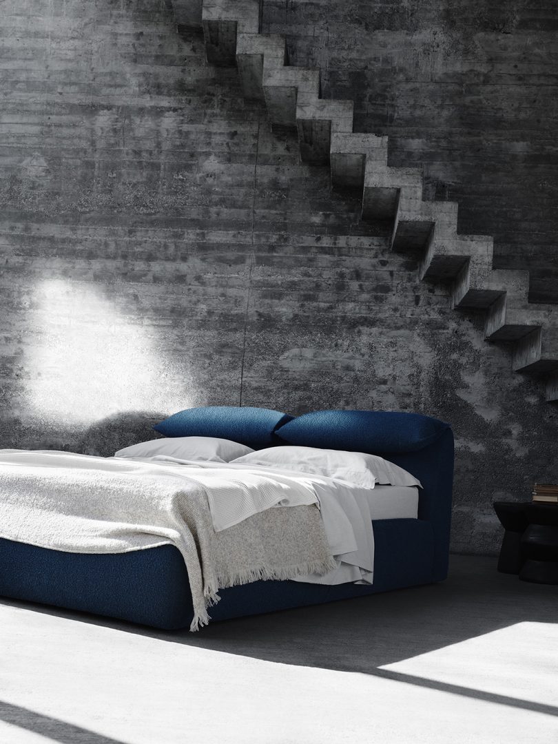 مبل آبی در یک تخت در مقابل یک دیوار آجری باز شد