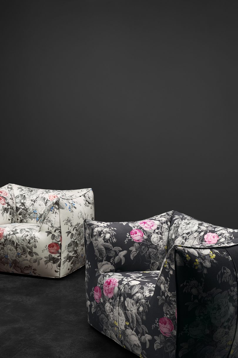 two floral covered armchairs on black background