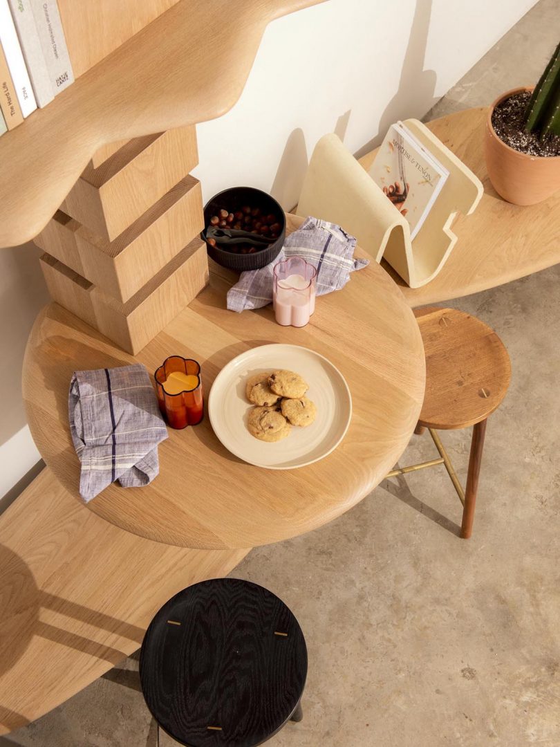 modular wood shelving styled with table and stools