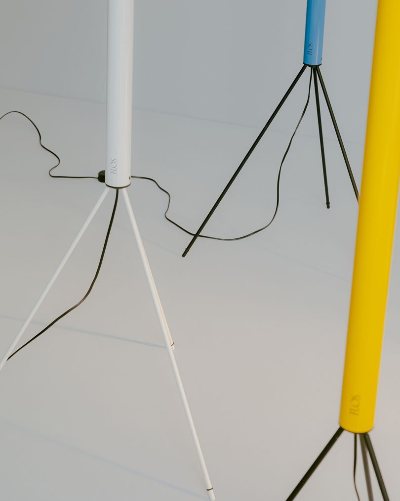 detail of yellow, white, and blue slim tripod floor lamps