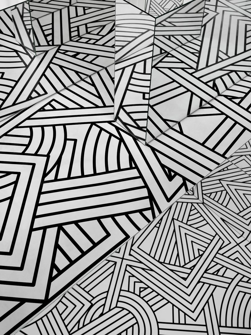 small exhibition filled with a black and white geometric pattern and lots of mirrors