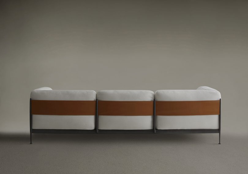 off white 3-seat sofa with black metal structure and surrounding "belt"