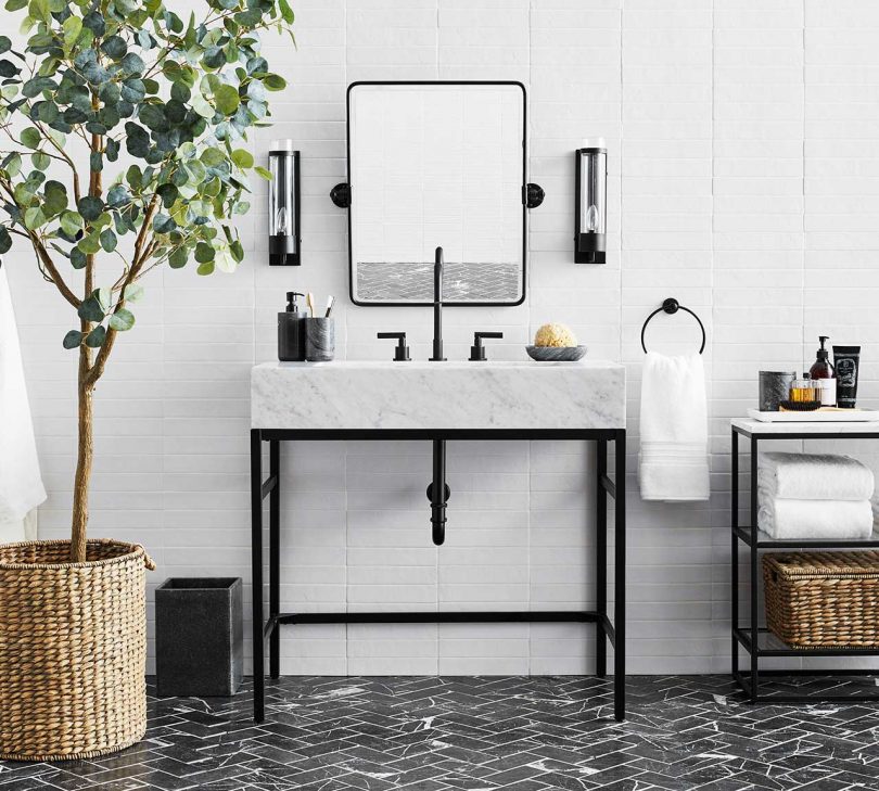 marble and black steel bathroom vanity in styled space