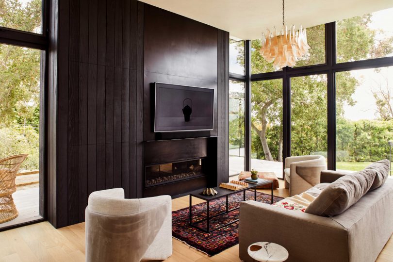 interior view of modern living room with black tv wall and wall of windows