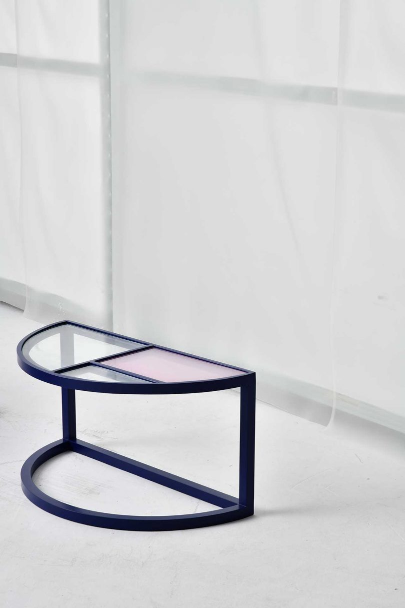 side table with black metal frame and pastel glass top