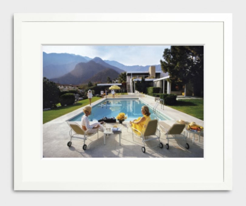 frame photo of two women seated in poolside lounge chairs in a whit frame on a white background