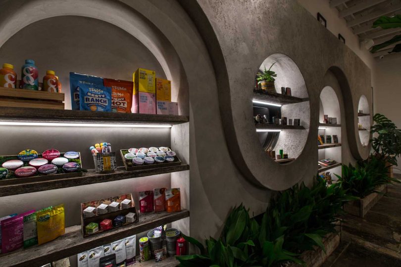 angled interior shot of cannabis dispensary with clay coated walls featuring cutouts acting as shelves
