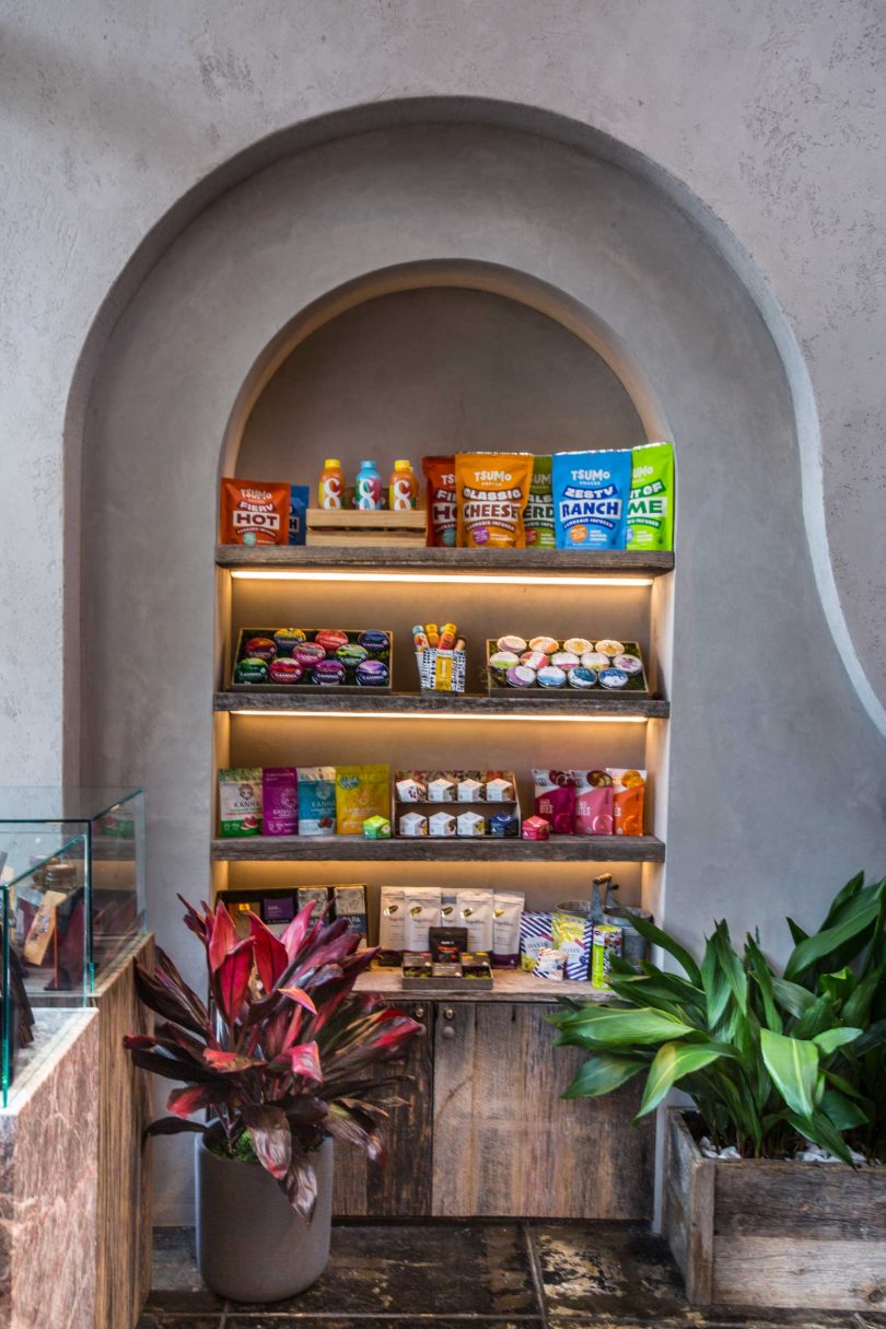 cannabis shop interior photo with wood and greenery accents and built-in shelf with lighted products