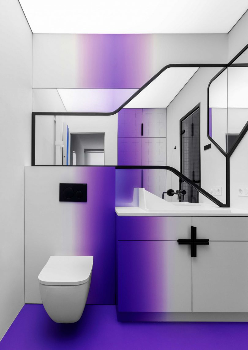 modern bathroom with white walls, graphic black accents, and gradient shades of purple