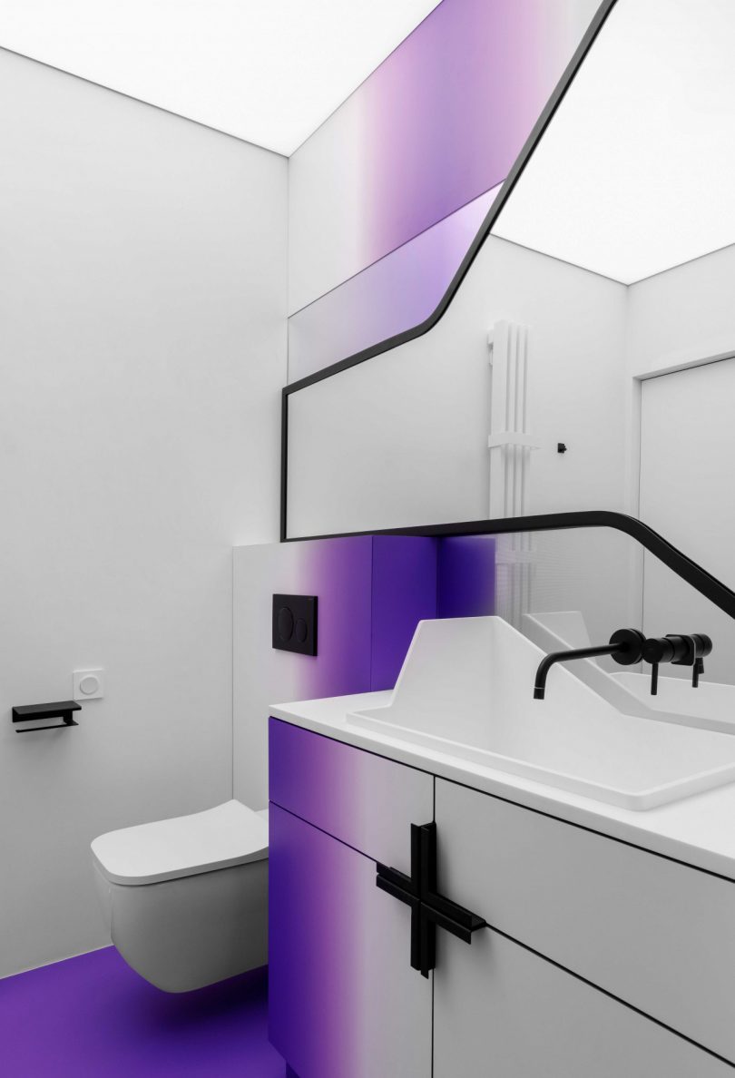 modern bathroom with white walls, graphic black accents, and gradient shades of purple