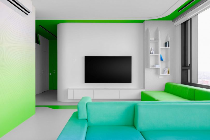 interior view of modern apartment living room with white walls and colorful green sofa