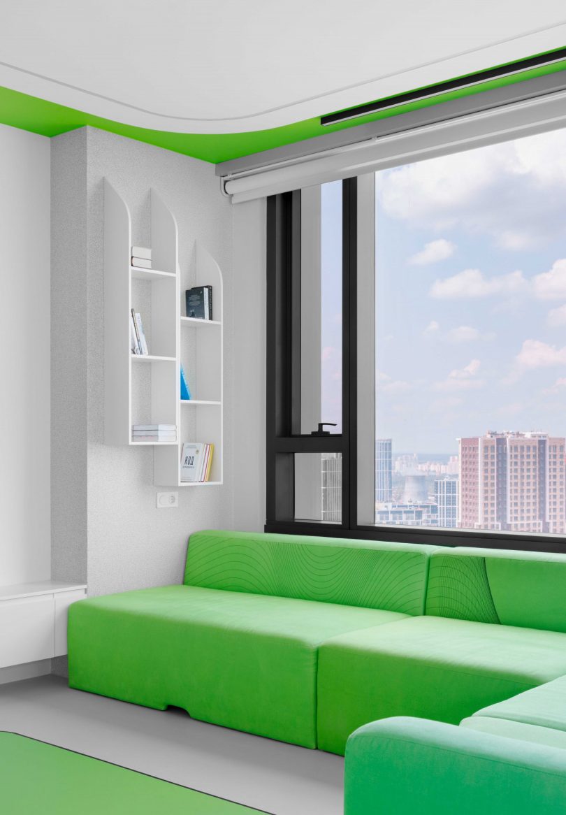 interior view of modern apartment living room corner with white walls and window and bright green sofa