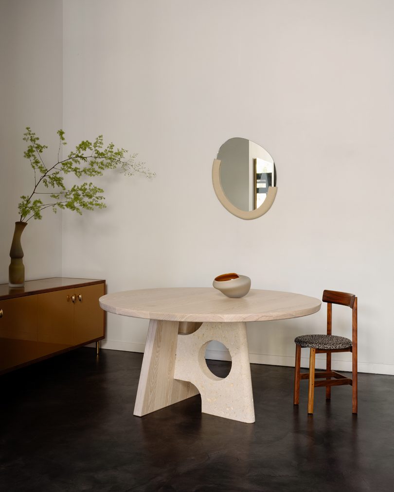 gallery space with round table, dining chair, credenza, and round mirror