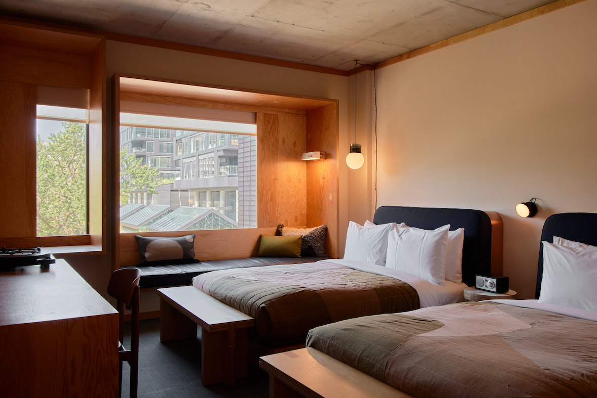 Guest suites are conceived as restful urban cabins, with Douglas fir paneling, copper accents, custom Shim- Sutcliffe lighting and side tables, and deep-set window benches built into the structure offering connection to the city’s shifting seasons and light
