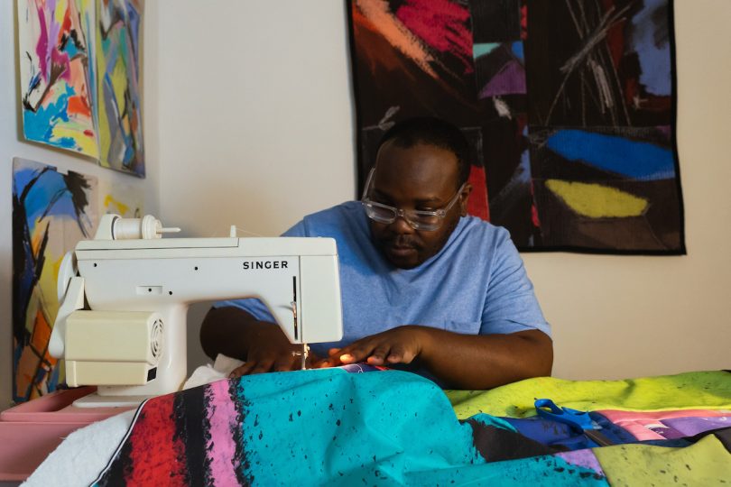 Black designer on sewing machine