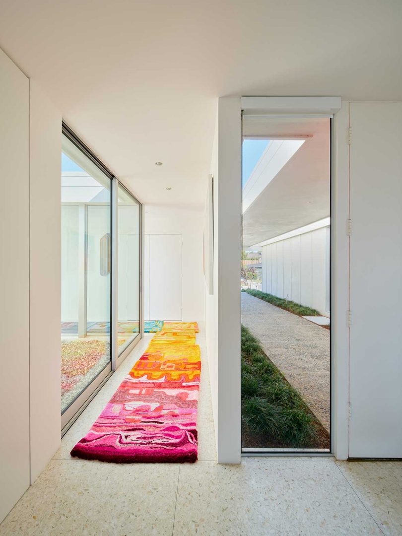hallway view with colorful rug and view of interior courtyard