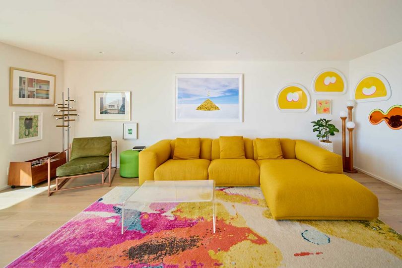 colorful living room in modern house with gold couch and colorful rug