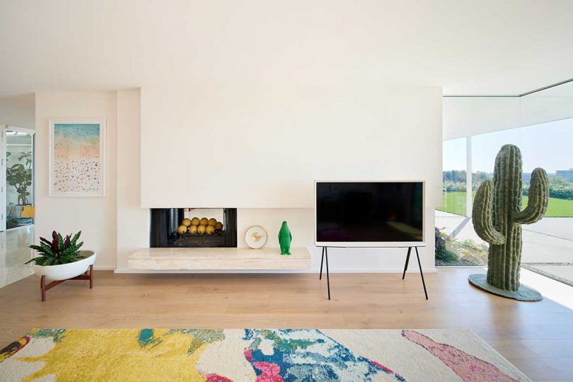 modern living room with colorful rug and view of tv stand