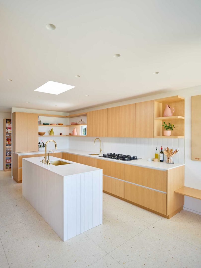 mid century modern home interior with minimalist light wood and white kitchen