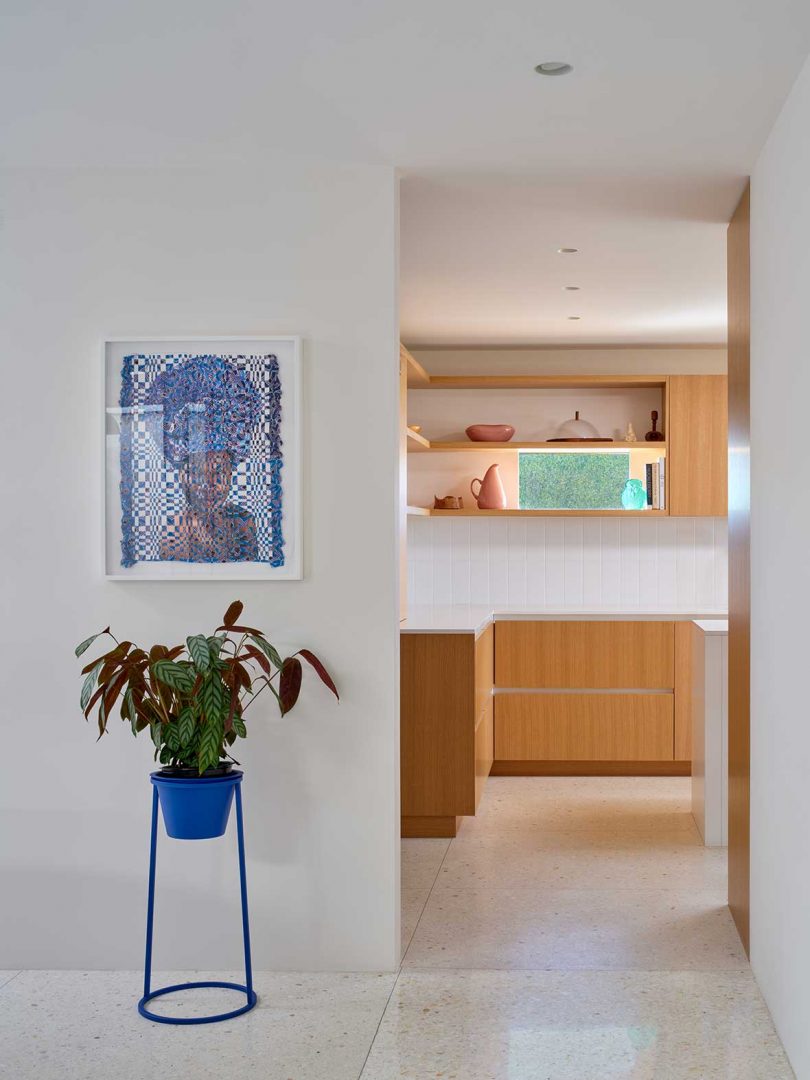 mid century modern home interior with minimalist light wood and white kitchen