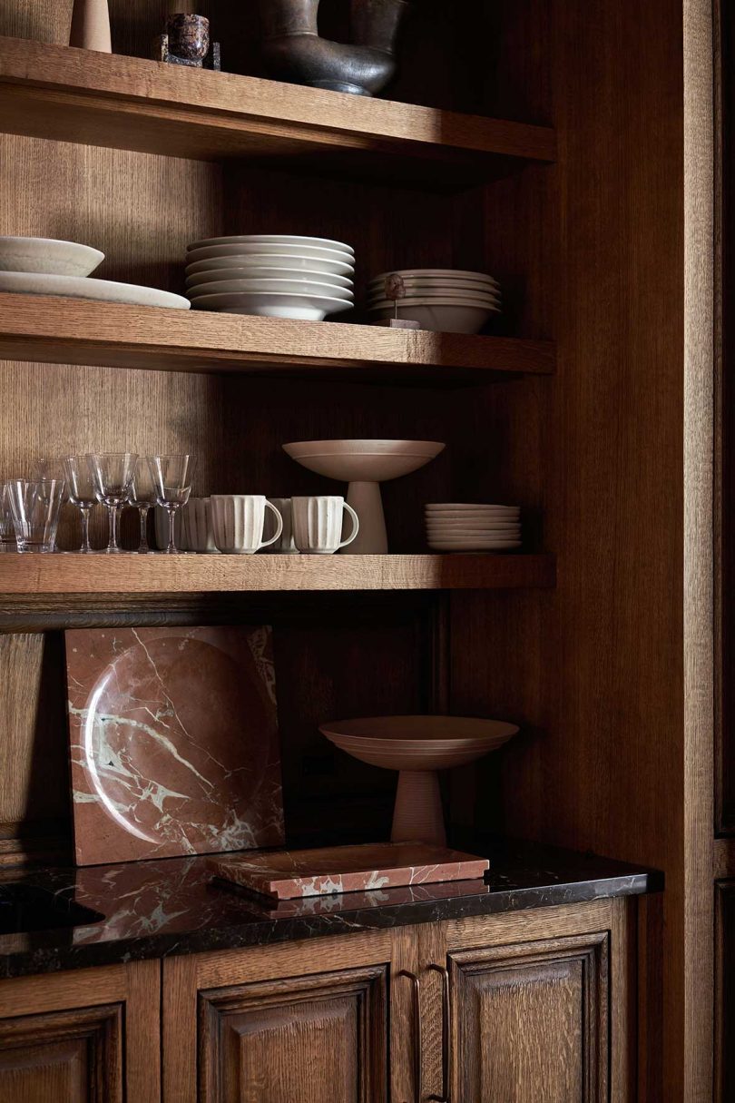 closeup of dark wood shelving system holding dishes and glassware