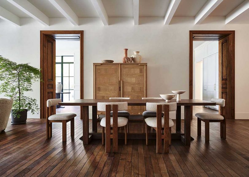 اتاق غذاخوری مدرن با میز چوبی بلند و بوکل سفید و صندلی های چوبی