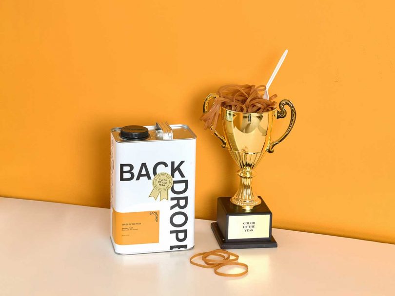 gold orange yellow painted wall with backdrop paint can and trophy