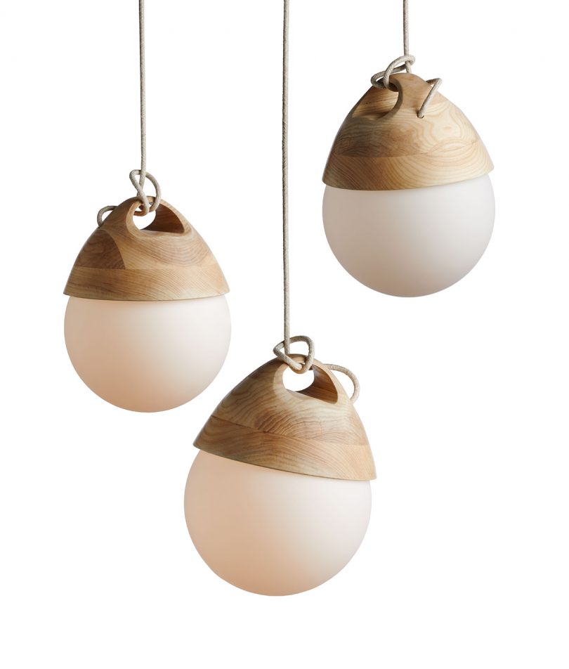 A trio of Booi pendant lamps hung at different heights against white background.