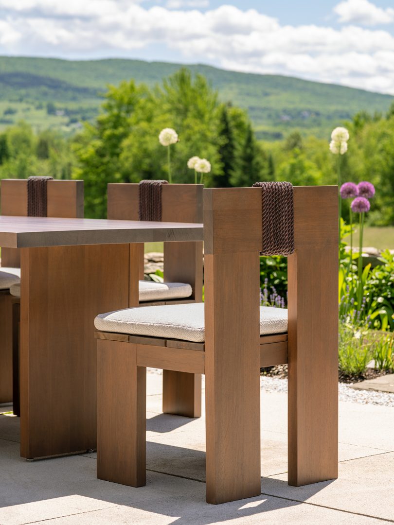 outdoor dining chair in wood sitting with a dining set outside