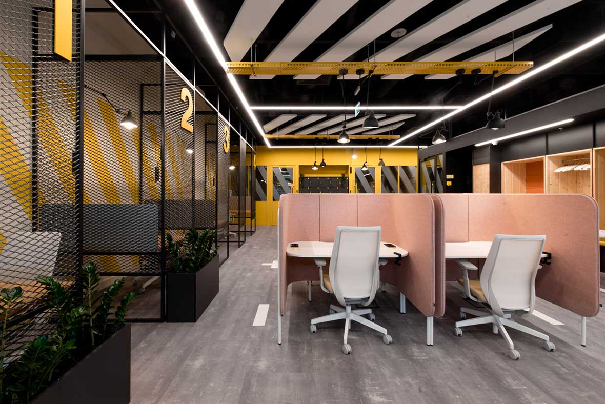 coworking space with graphic black and white patterns and bold colors and pink workstations