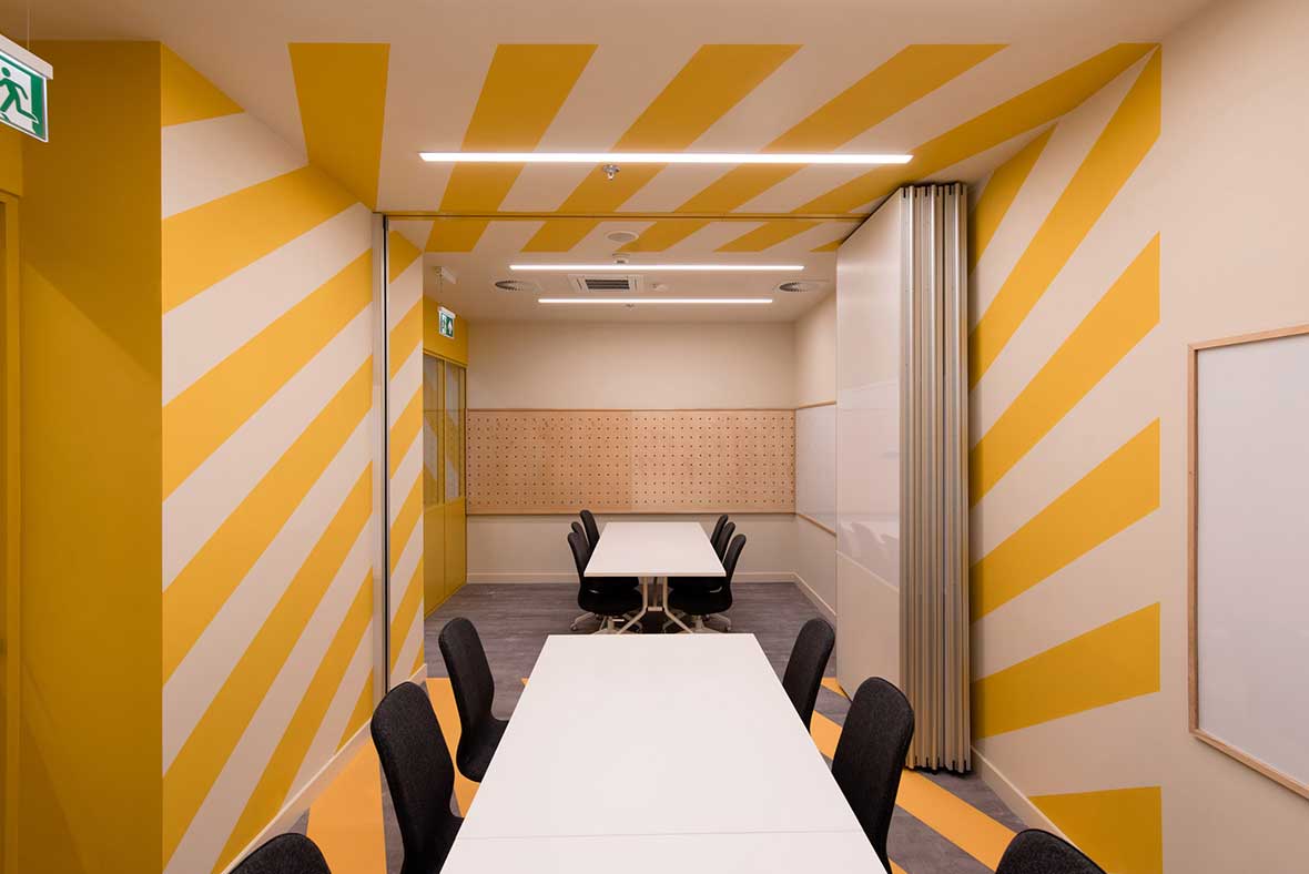 modern coworking space conference room with yellow and white diagonal stripes