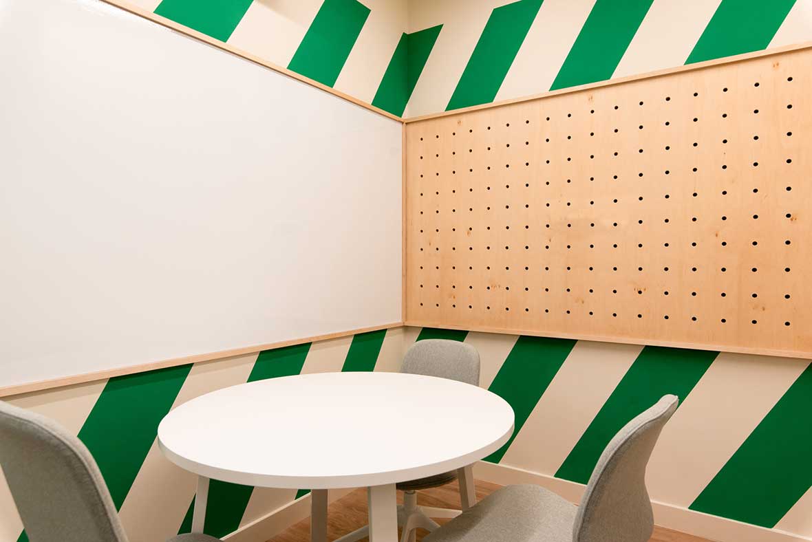 modern coworking space conference room with green and white diagonal stripes