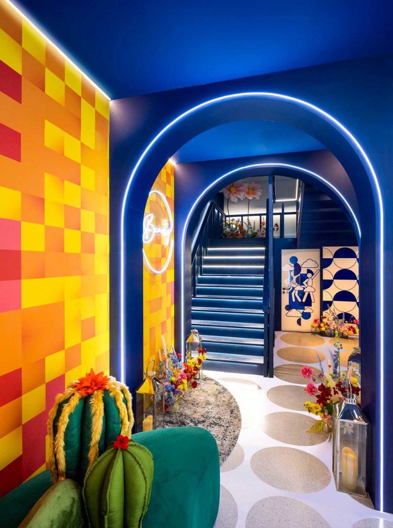 colorful hallway with blue arches and stairs in background