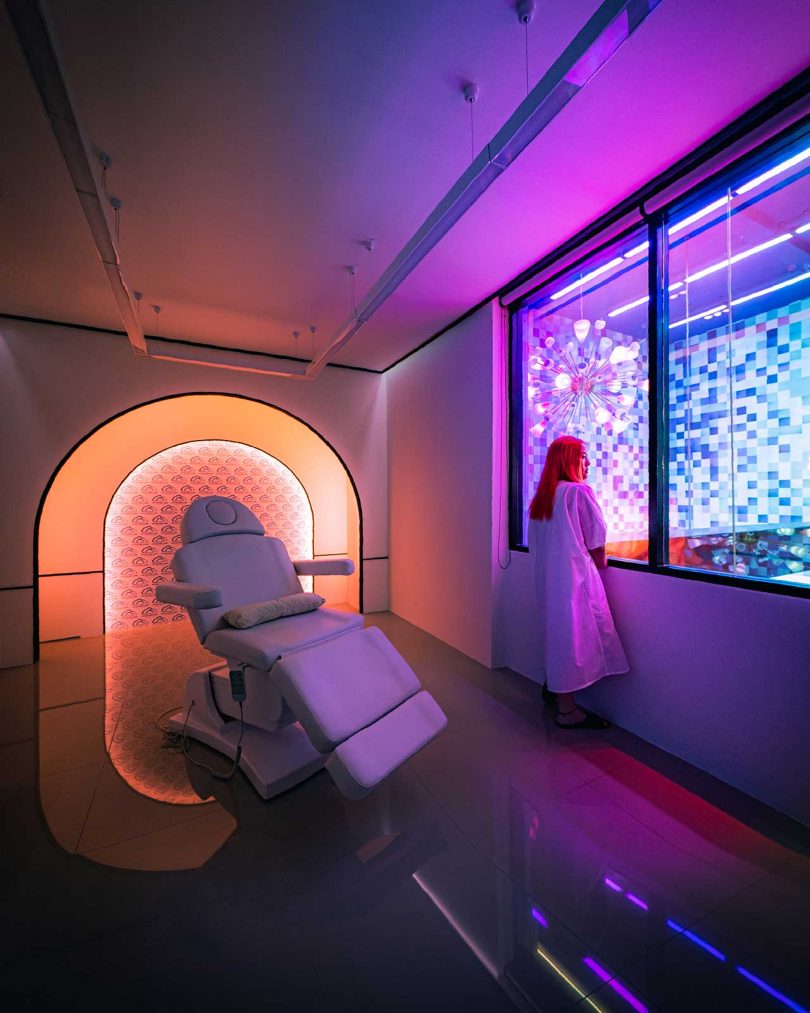 modern med spa patient room with neon lights and woman looking out 