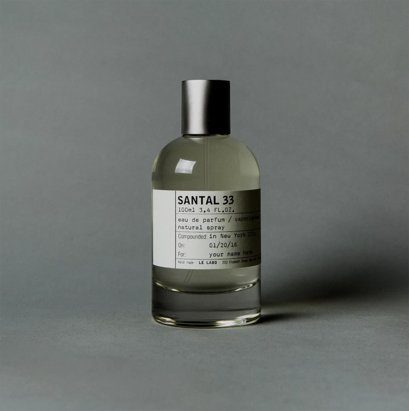 simple bottle of perfume with silver cap and white label on grey background