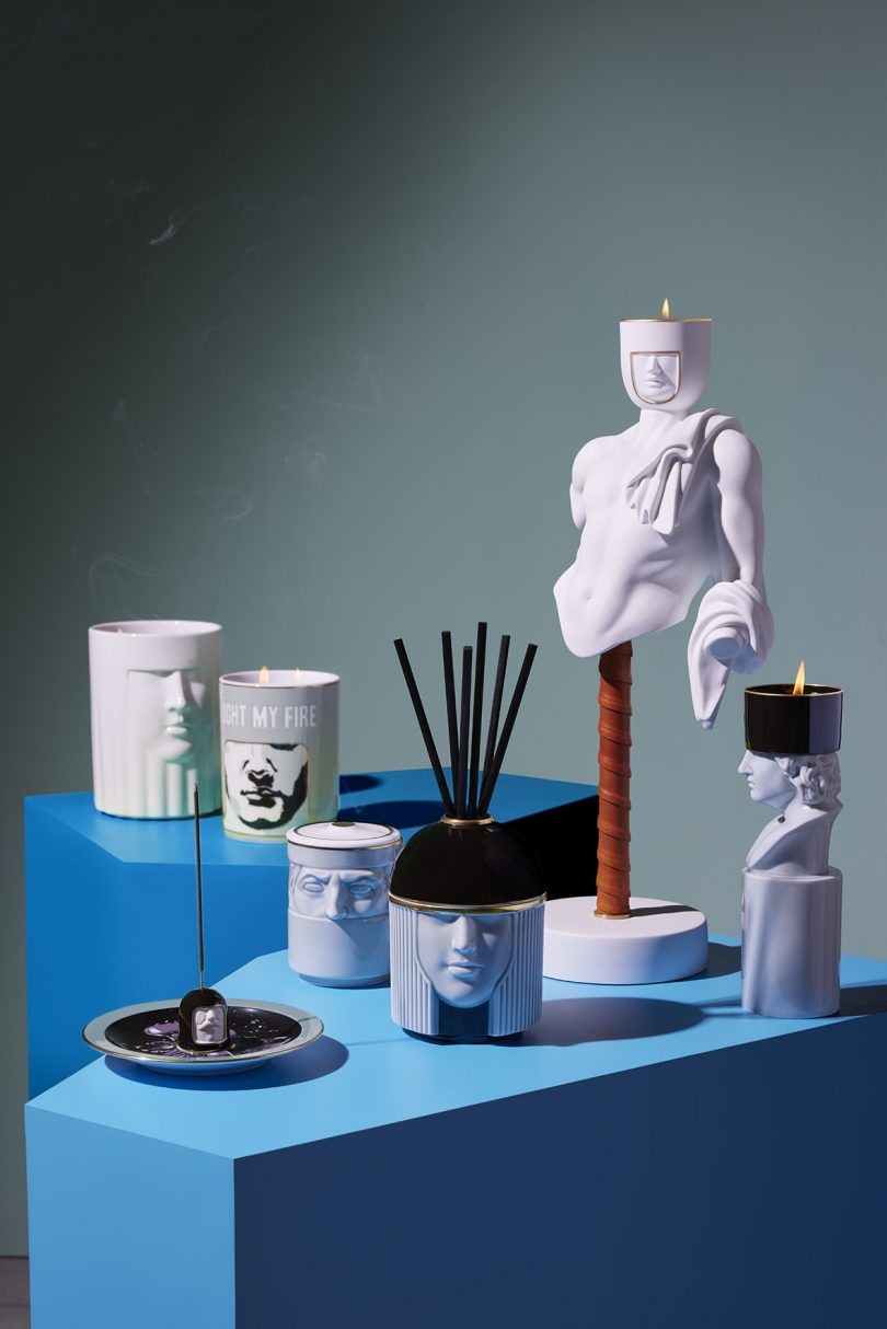 a display of candles, diffusers, candleholders and more displayed on blue plinths