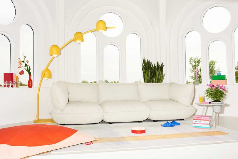 modern living space with white sofa and arched yellow floor lamp