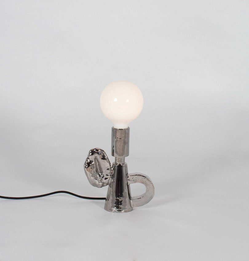 mirrored shade-free table lamp on a light grey background