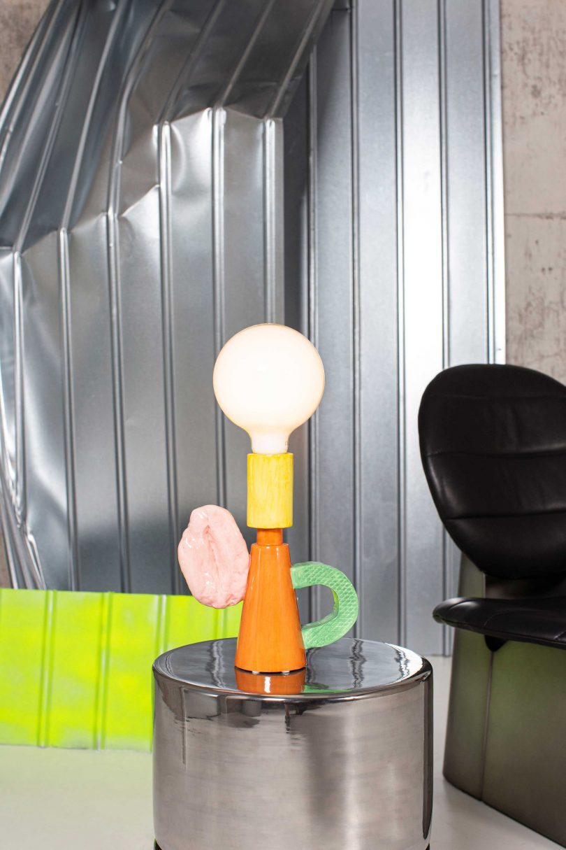 colorful shade-free table lamp on an end table in a styled space