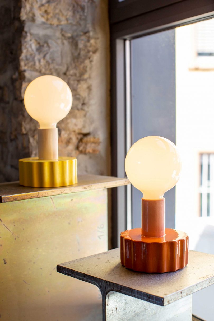 two colorful shade-free table lamps in a styled space