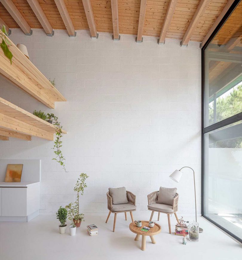 فضای داخلی خانه مینیمالیستی با سطوح سفید و جزئیات چوبی