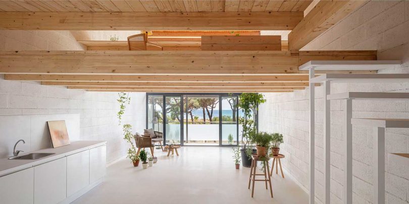 Diseño interior sencillo con encimeras blancas y detalles de madera que se asoman por las ventanas delanteras