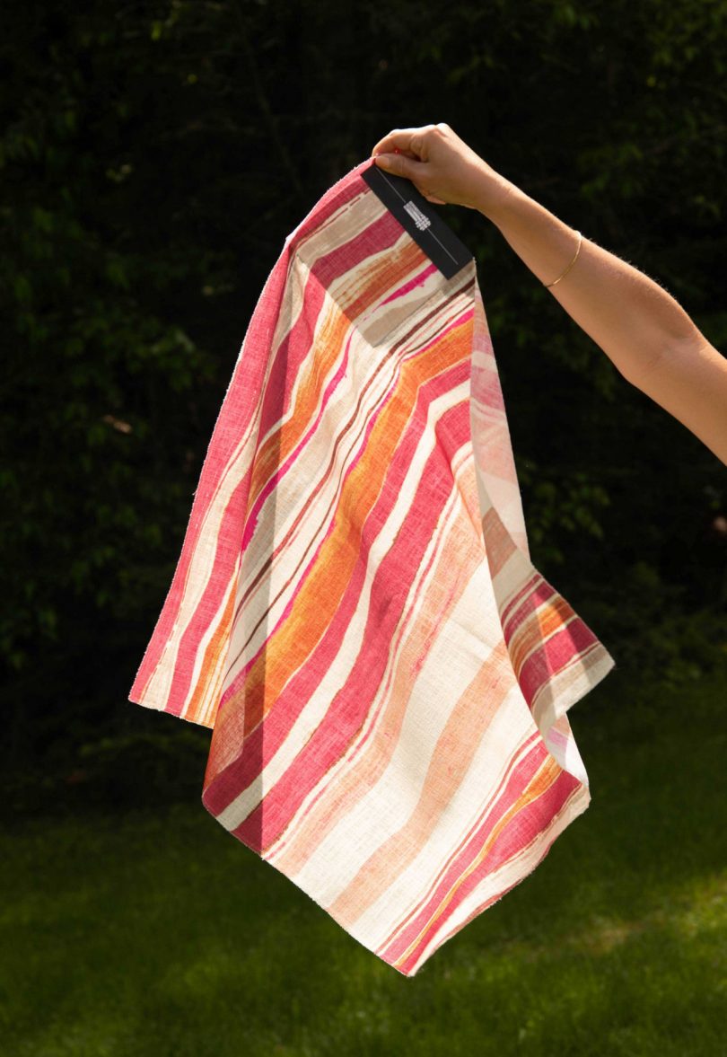 arm holding a striped fabric swatch
